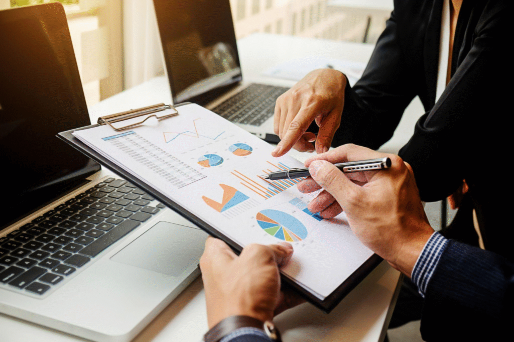 Two professionals discussing financial charts and data on a report.